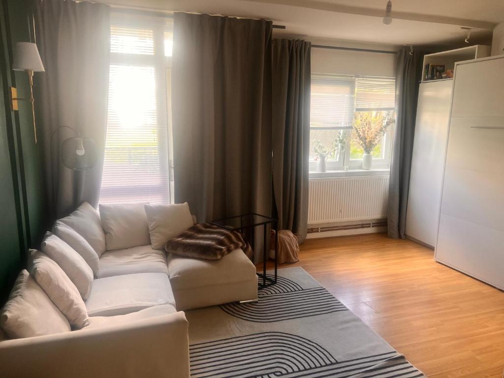 a living room with a white couch and a window at A little spot in the City in London