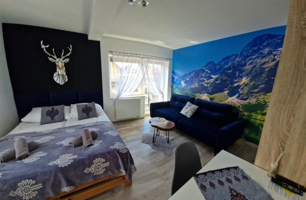a bedroom with a bed and a blue couch at Pokoje i apartamenty Wierchy Zakopane in Zakopane