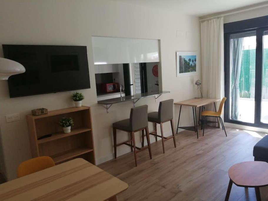 ein Wohnzimmer mit einem Tisch, Stühlen und einem TV in der Unterkunft Ribera del Guadalquivir in Camas