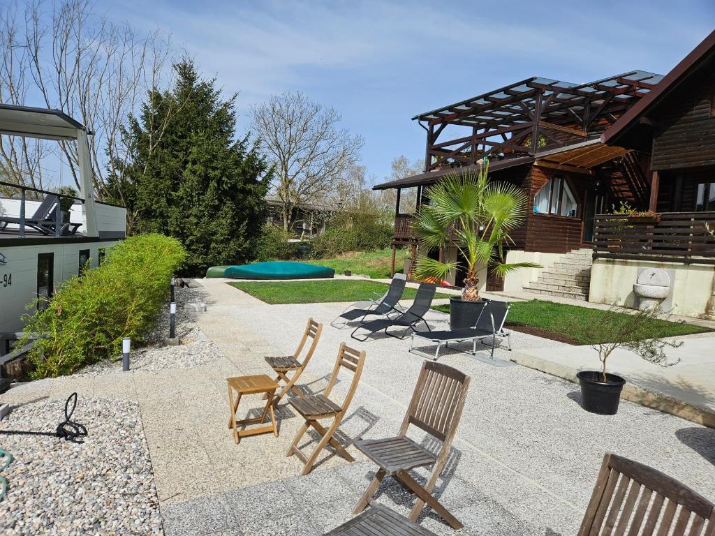 un patio con sedie, tavolo e una casa di River Houses Ljubljanica a Lubiana
