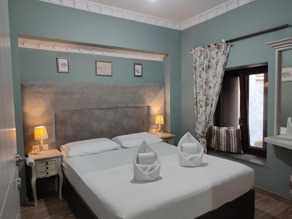 a bedroom with a large white bed and a window at Green House Skiathos in Skiathos