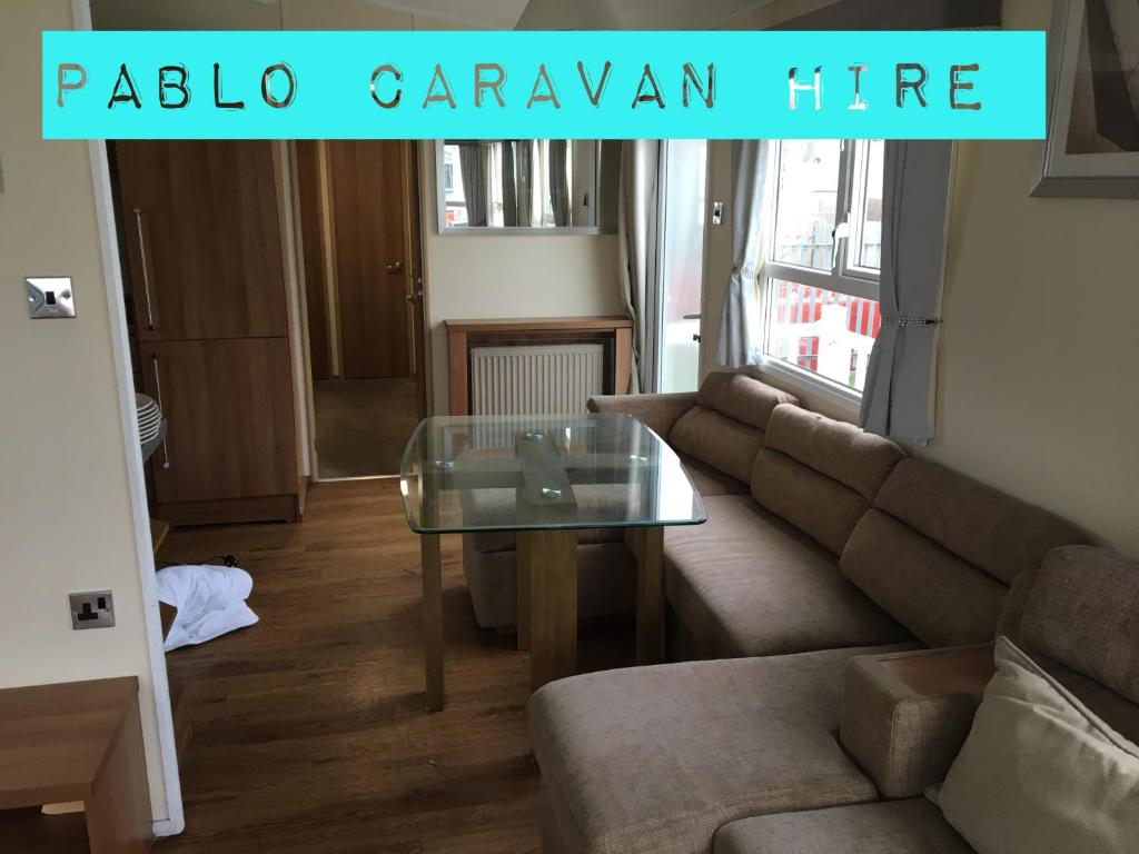 a living room with a couch and a glass table at 3 Bedroom 8 Berth Caravan Towyn in Rhyl