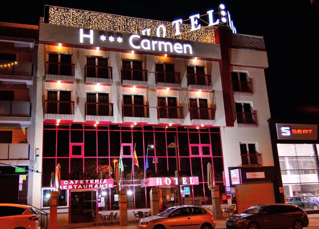 un bâtiment avec un panneau en haut de celui-ci la nuit dans l'établissement Hotel Mari Carmen, à Guadix