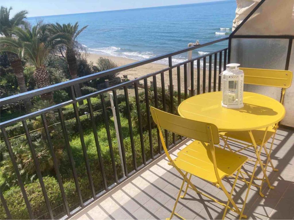 a yellow table and chairs on a balcony with the beach at Sabina's House in Acciaroli