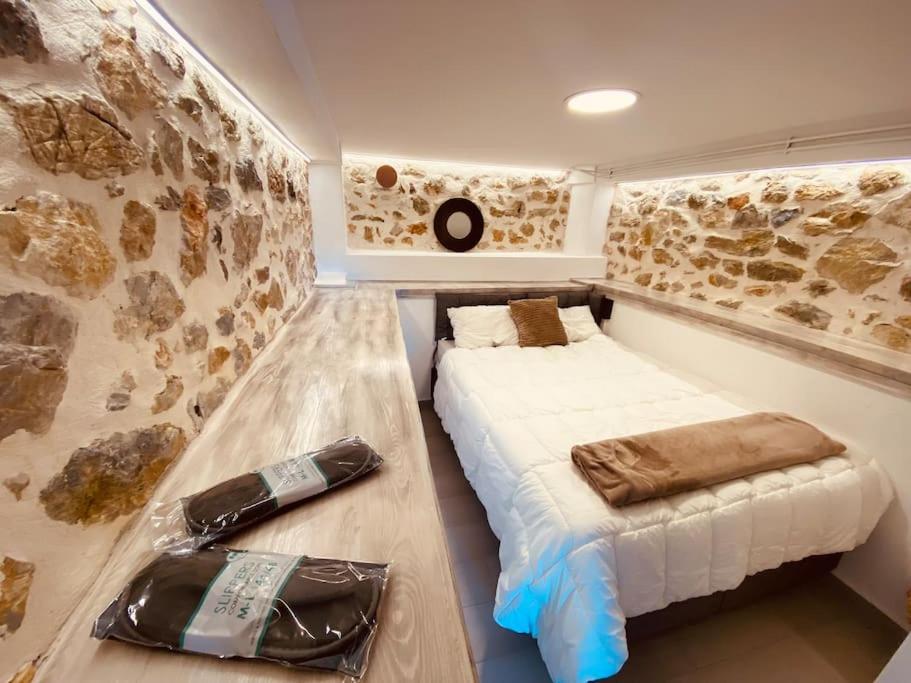 Habitación pequeña con cama y sofá en calm stone house elemm, en Kastoria