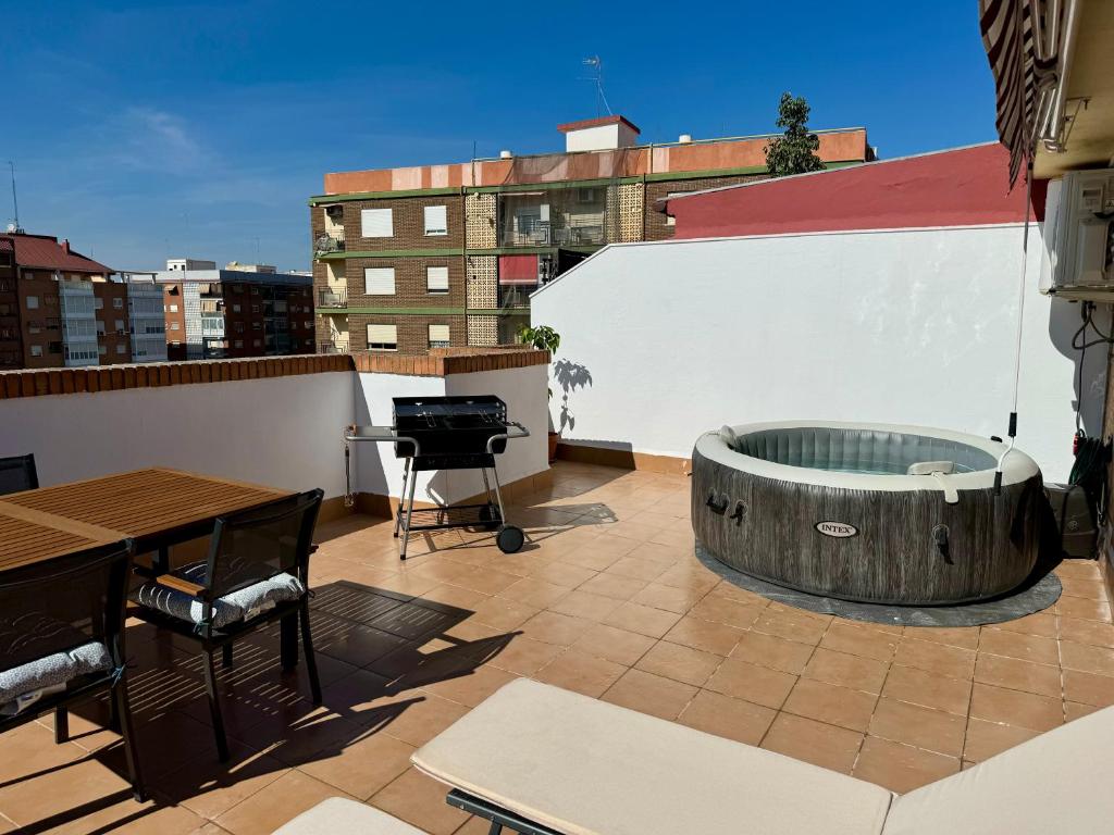 a rooftop patio with a hot tub and a grill at Your Long Stay Attic Home in Valencia in Valencia