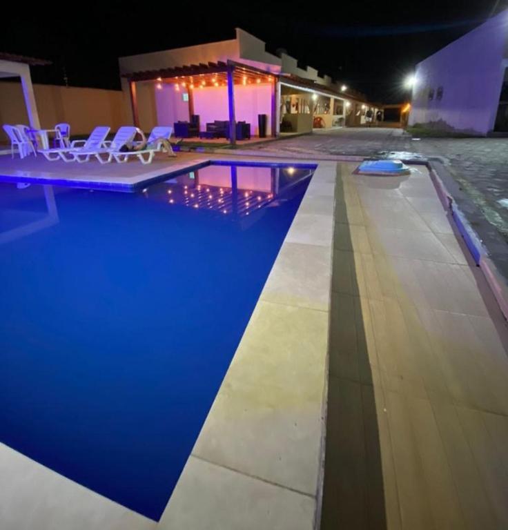 a pool with chairs next to a building at night at Dunas residence casa 03 in Santo Amaro