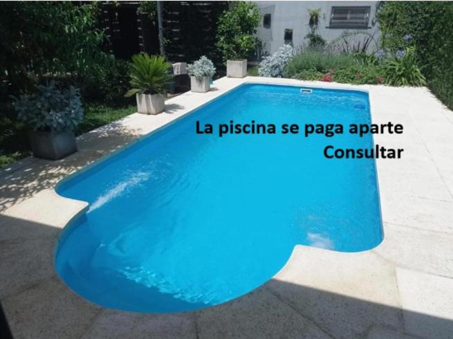 uma grande piscina azul num quintal em Tres Chihuahuas & Spa em Mariano Moreno