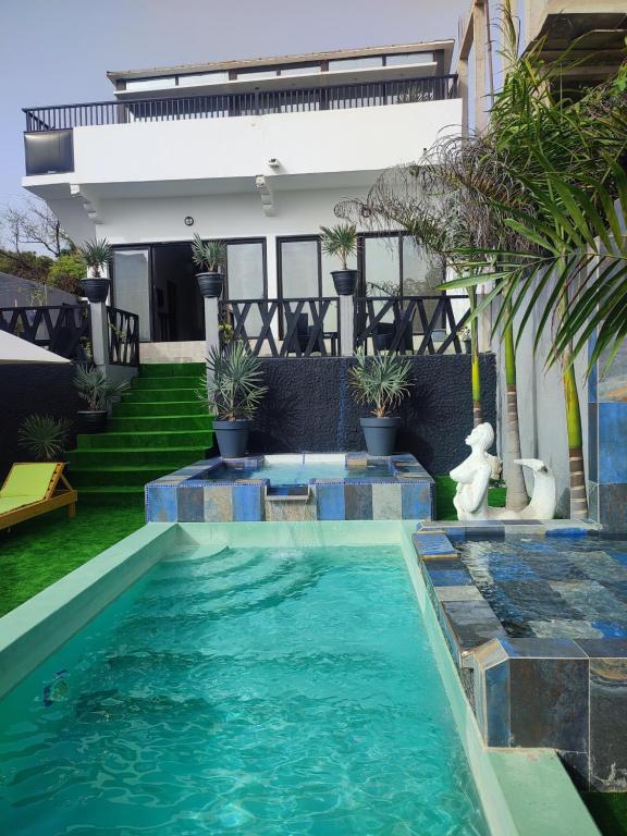 a swimming pool in front of a house at La residence latinaya in Poponguine
