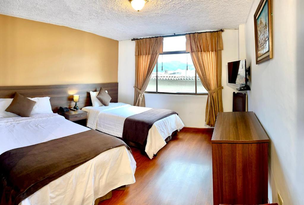 ein Hotelzimmer mit 2 Betten und einem Fenster in der Unterkunft Loft NASS Atahualpa in Cuenca