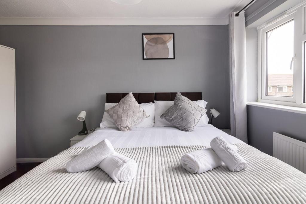 Un dormitorio con una cama con almohadas blancas. en The Kilnwood House, en Crawley