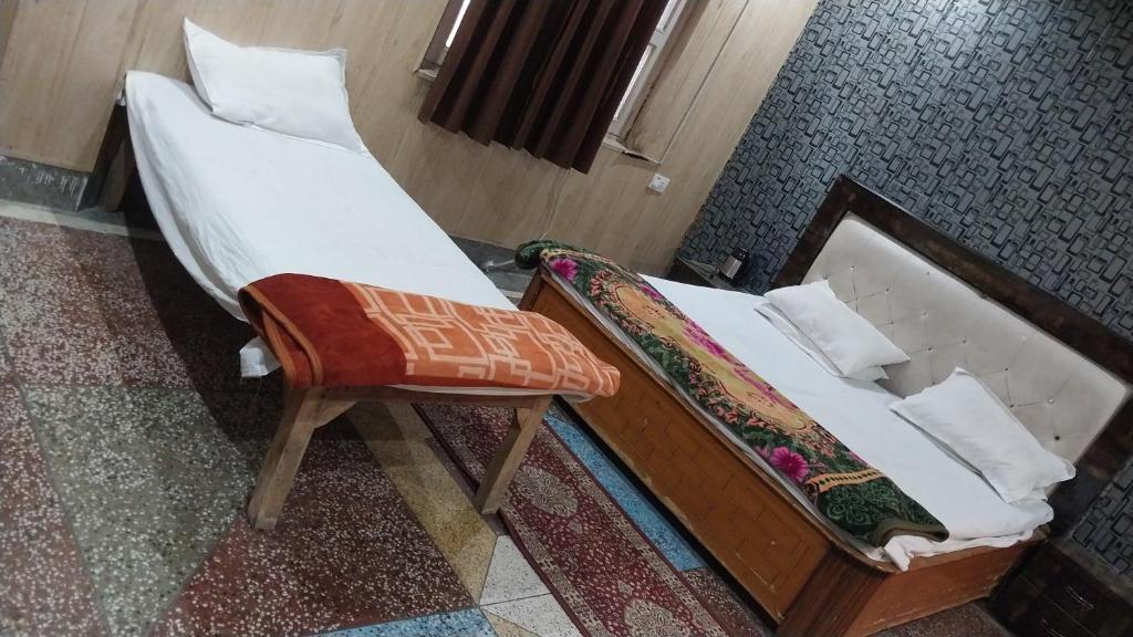 a bedroom with a bed and a chair in it at Somnath residency radhe nikunj in Vrindāvan