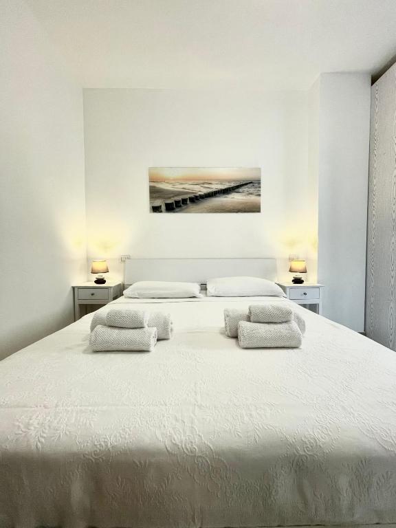um quarto branco com uma cama grande e 2 almofadas em Sea la Vie em Alghero
