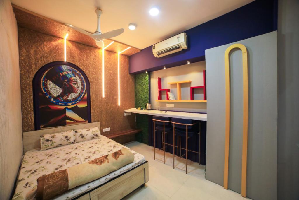 a small bedroom with a bed and a kitchen at Ramashray Premium Studio Apartments in Kanāria