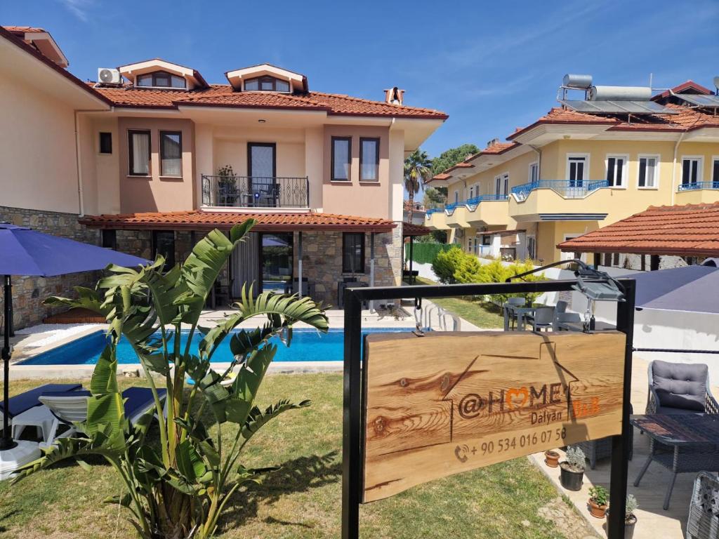 a sign in front of a house with a swimming pool at @Home Dalyan in Dalyan