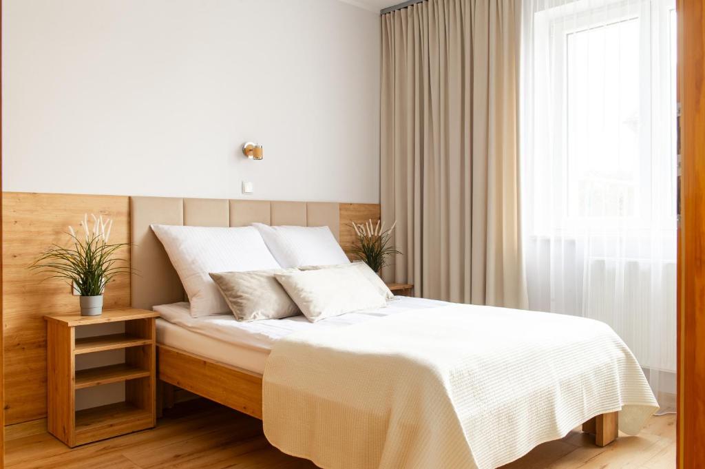a bedroom with a bed with white sheets and a window at Willa Karol in Karwia
