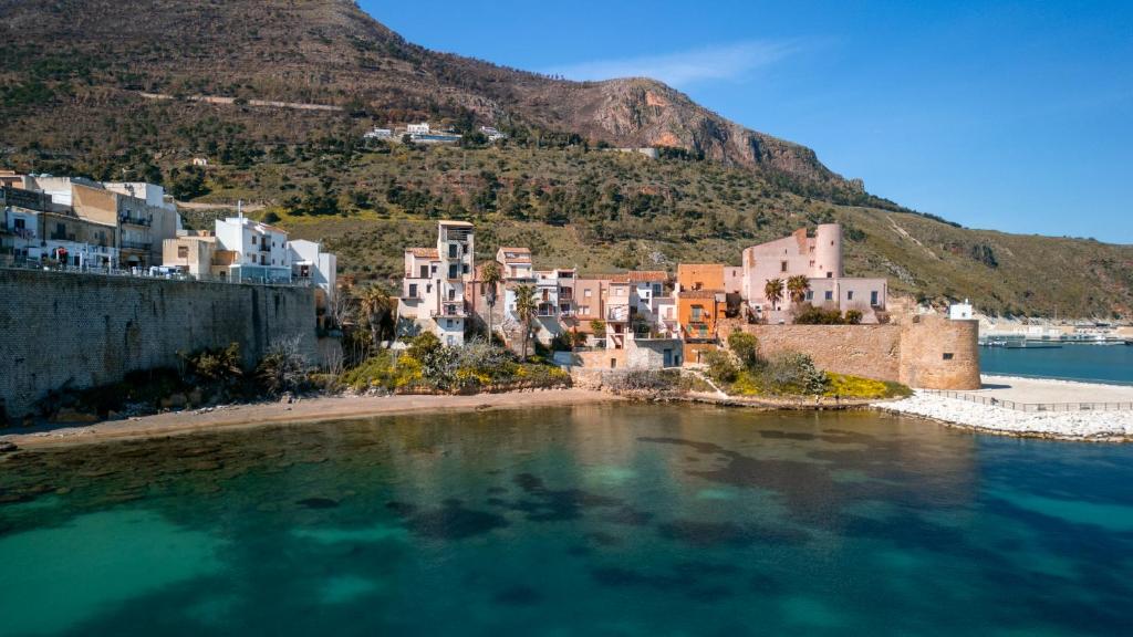 a group of houses on a small island in the water at La Casetta sul mare in Castellammare del Golfo