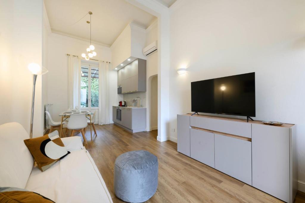 un salon avec une télévision à écran plat sur un mur blanc dans l'établissement Michelangelo Luxury Apartment, à Florence