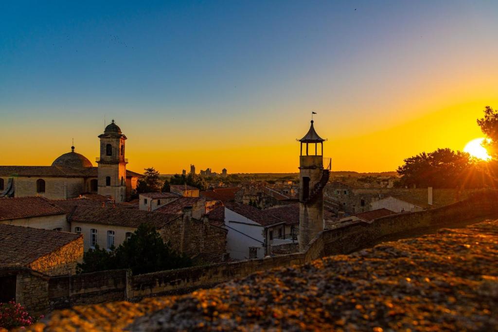 - une vue sur une ville avec le coucher du soleil en arrière-plan dans l'établissement Breathtaking Terrace Views, à Beaucaire