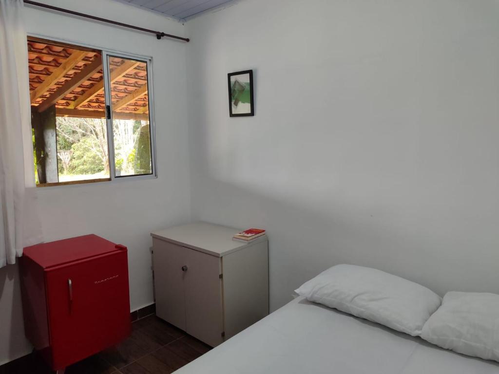 een slaapkamer met een bed en een raam bij Sítio na Mata Atlântica in Tapiraí