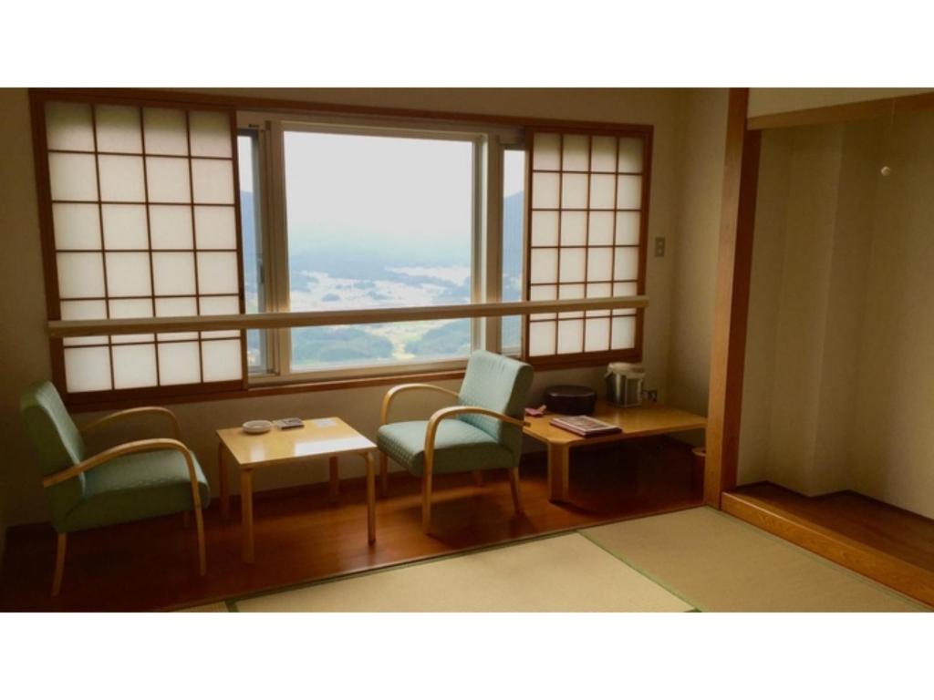 KyōmendaoにあるIkoi no Mura Shimane - Vacation STAY 27386vの椅子とテーブル、窓が備わる客室です。