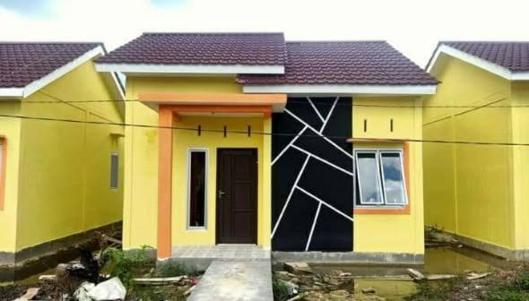 Una casa con un cuadro a un lado. en Rumah PP Supadio, en Limbung