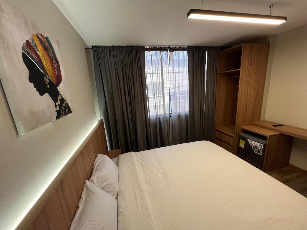 a small bedroom with a bed and a window at Aerosuites in Bogotá