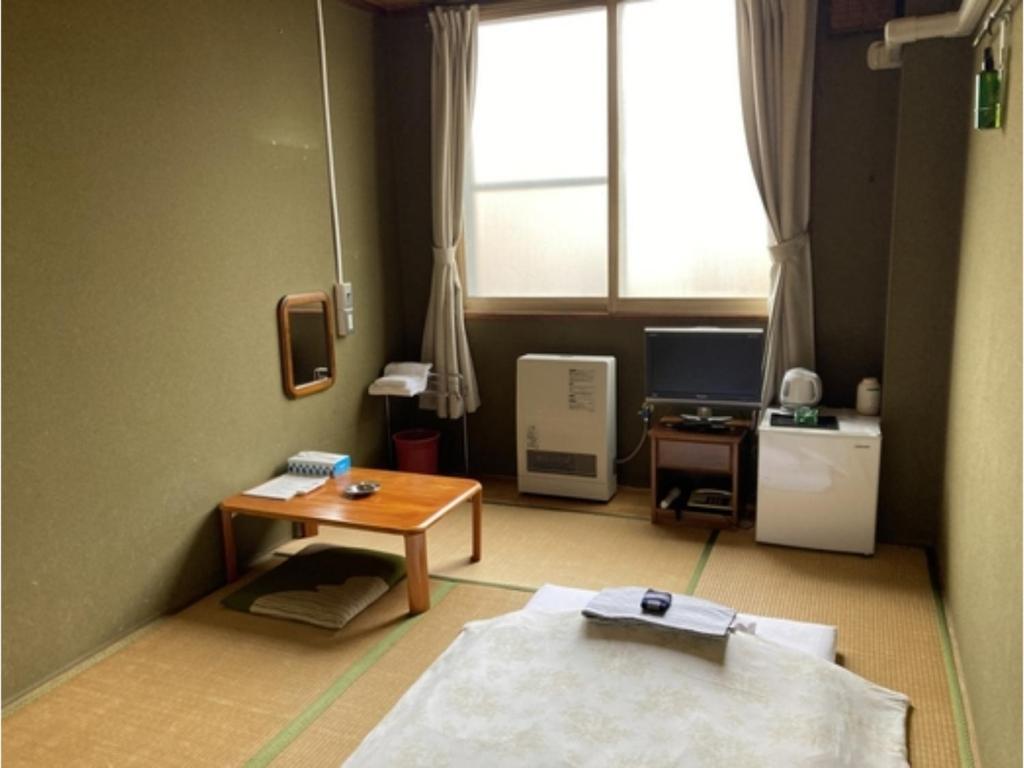 函館市にあるHotel Tetora Yunokawaonsen - Vacation STAY 30606vのテーブル、デスク、窓が備わる客室です。