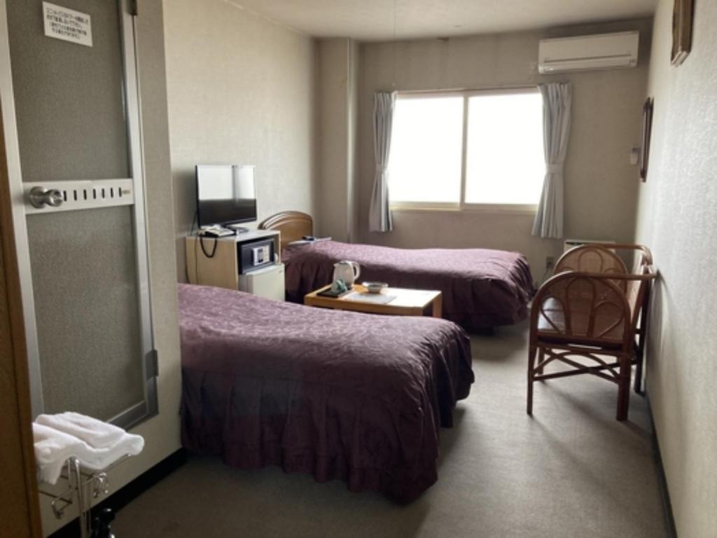 een hotelkamer met 2 bedden en een raam bij Hotel Tetora Yunokawaonsen - Vacation STAY 30623v in Hakodate