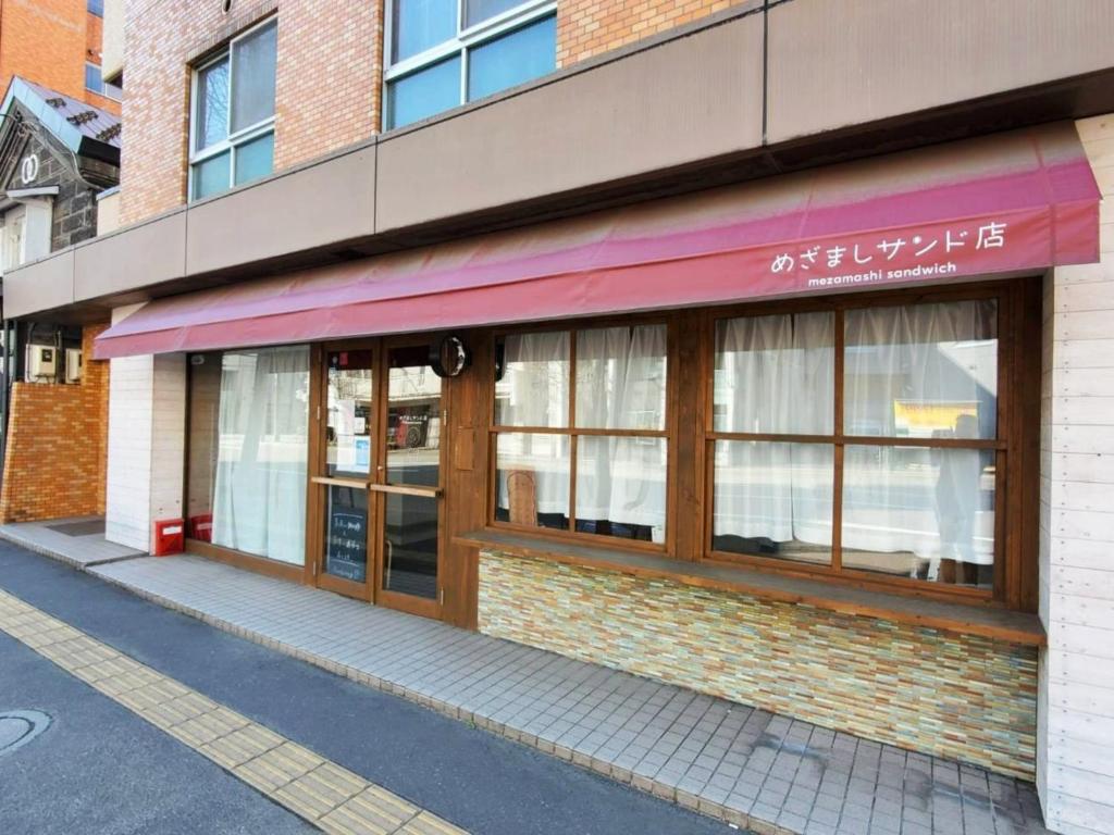 una tienda frente a un edificio con ventanas en EZO Run Sapporo - Vacation STAY 34518v en Sapporo