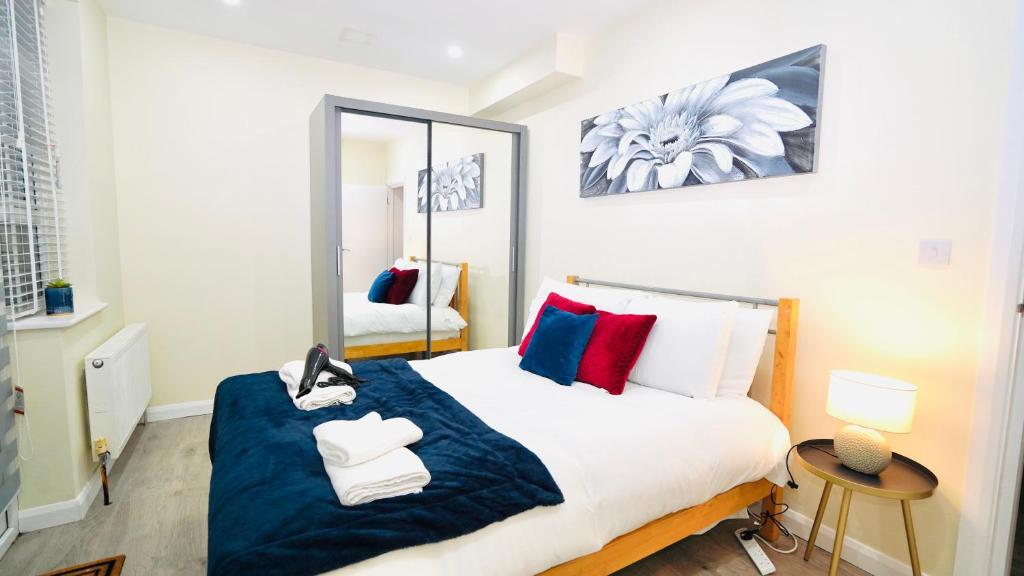 雷德布里奇的住宿－F3 Ground floor Luxury flat Gants Hill，一间卧室配有一张大床和镜子