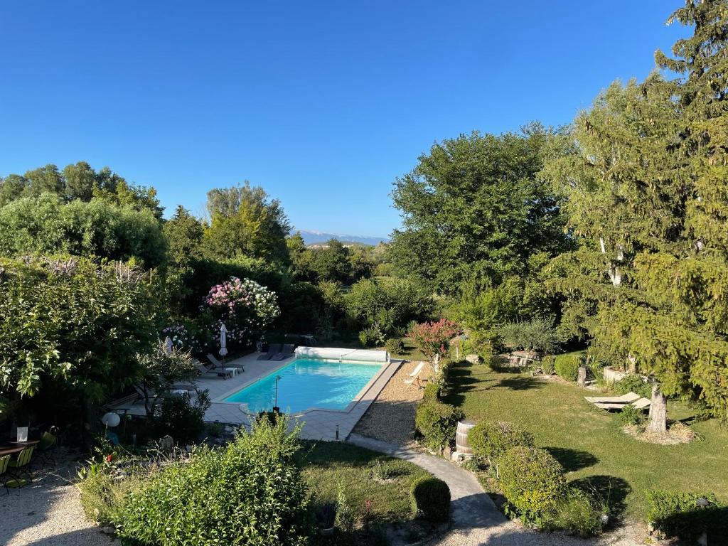 een uitzicht over het zwembad in de tuin bij La Petite Rive - Les Oliviers in Velleron