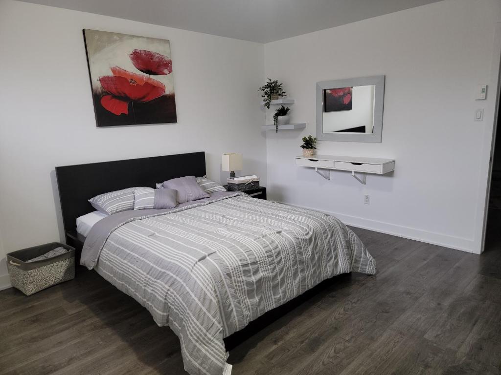 a bedroom with a bed in a white room at Confort Full Basement nothing shared in Longueuil