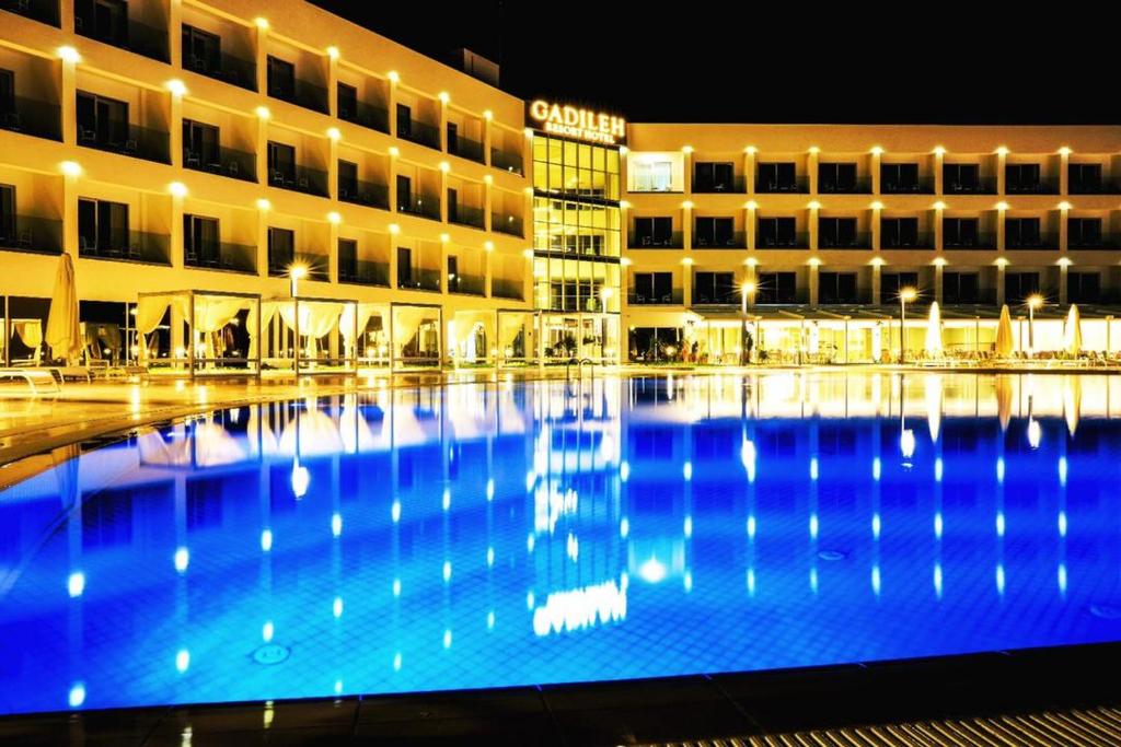 un gran edificio con una gran piscina por la noche en Gadileh Resort Hotel, en Yibuti