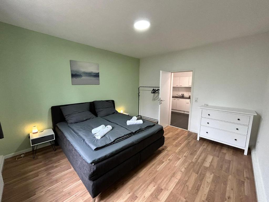 海爾布隆的住宿－Zentrale 3Zimmer Wohnung mit Stellplatz，一间卧室配有黑色的床和白色梳妆台