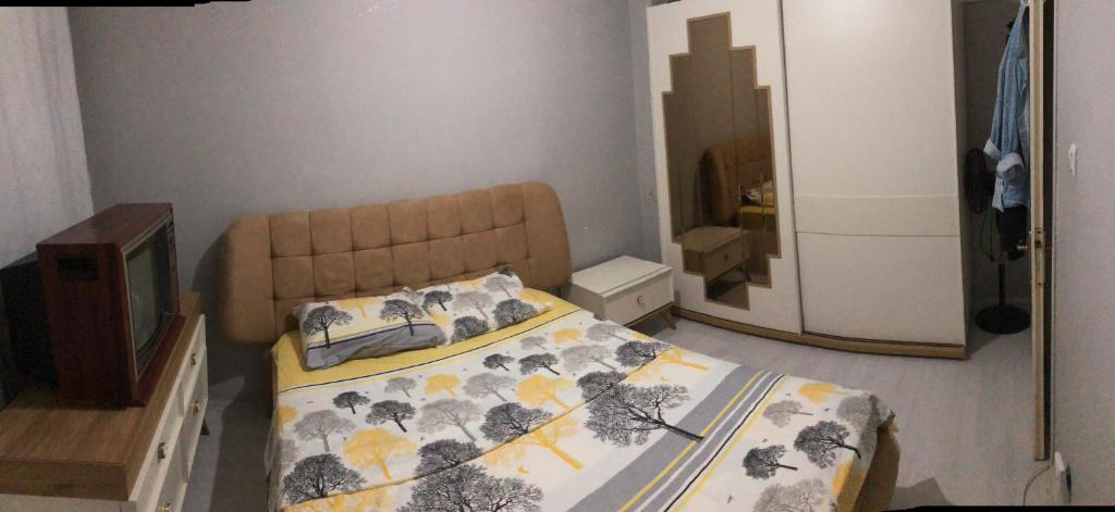 Dormitorio pequeño con cama y espejo en Erdemli/Mersin 2+1 Deniz kenarı Eşyalı Daire, en Erdemli