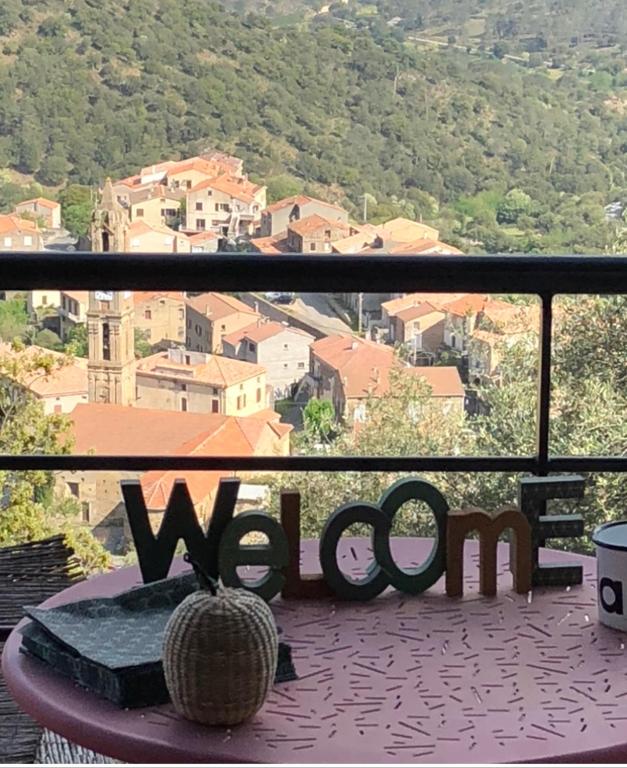 d'un balcon avec vue sur une ville et un panneau d'alarme. dans l'établissement Le SAN PETRONE-TOUR EN PIERRE EN CENTRE CORSE ENTRE MER ET MONTAGNE, à Moltifao
