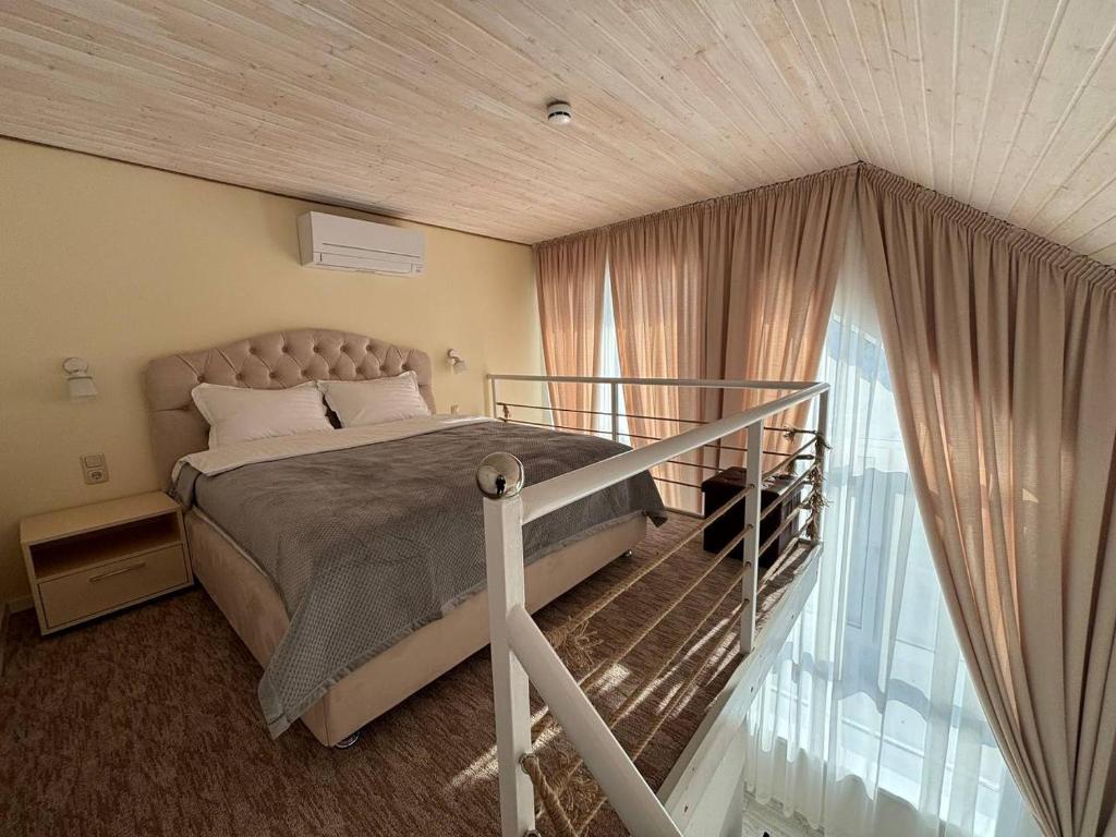 1 dormitorio con cama y ventana grande en Pensiunea Ancuței, en Şerpeni