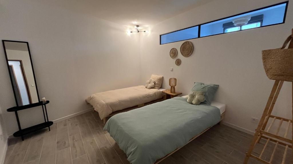 ein Zimmer mit zwei Betten und einem Fenster in der Unterkunft ÂU-LAC loft rénové en 2024 in Lourdes