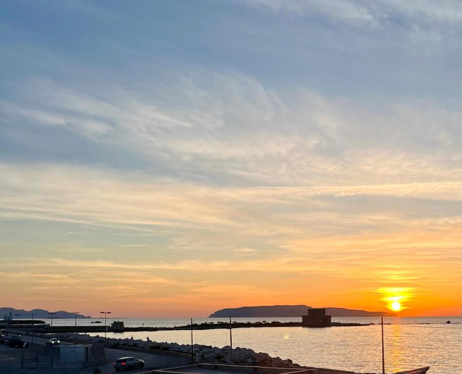 a sunset over a body of water with the sun setting at La Rizzaia casa indipendente in Trapani