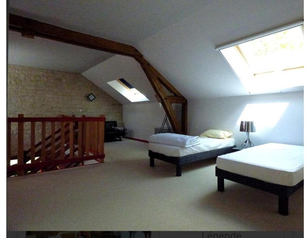 - une chambre avec 2 lits et une lucarne dans l'établissement Gite Loft 3 étoiles, à Tresnay