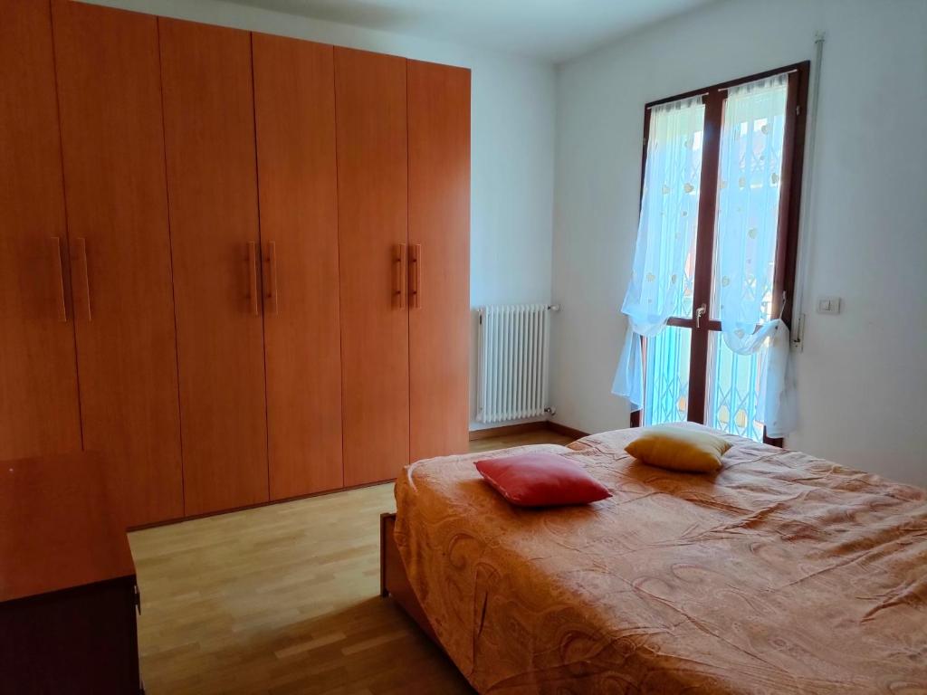 een slaapkamer met een bed en een groot raam bij La casa del Sole a Cesena in Cesena