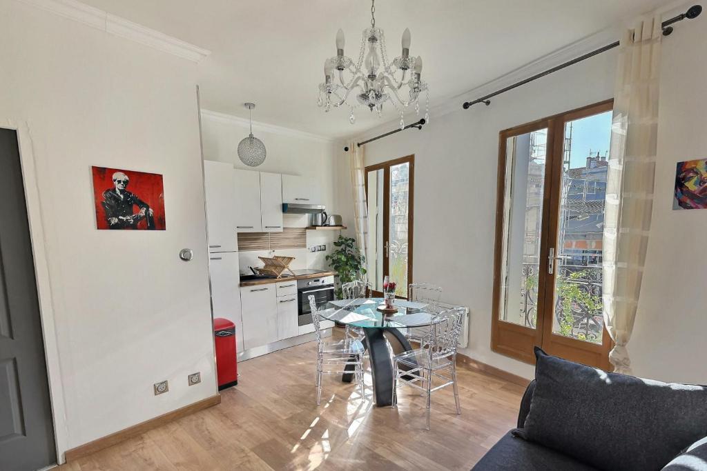 sala de estar con mesa y cocina en Appartement de charme avec balcon au pied des commerces en Béziers