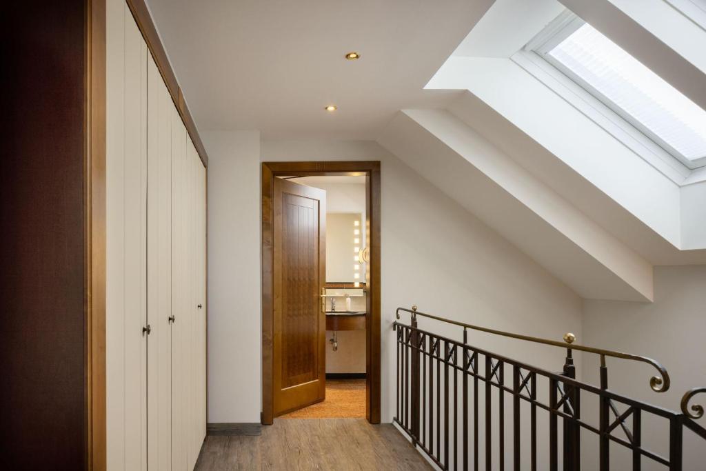 an attic hallway with a skylight and a staircase at Arabella Jagdhof Resort am Fuschlsee, a Tribute Portfolio Hotel in Hof bei Salzburg