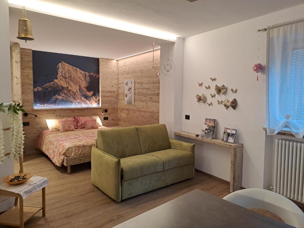 a bedroom with a bed and a couch and a chair at Monolocale La Rosa in Levico Terme