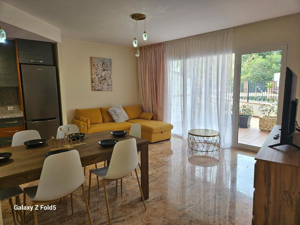 uma sala de estar com um sofá, uma mesa e cadeiras em Piso acogedor en Alcaucin em Alcaucín