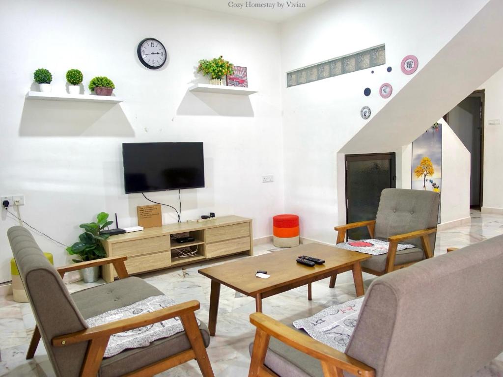 a living room with a tv and a table at Ipoh Cozy Homestay for 10-13pax in Ipoh