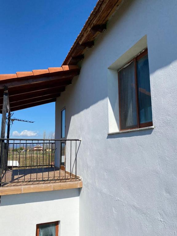 a white building with a balcony and a window at Bert-House close to the sea in Lezhë