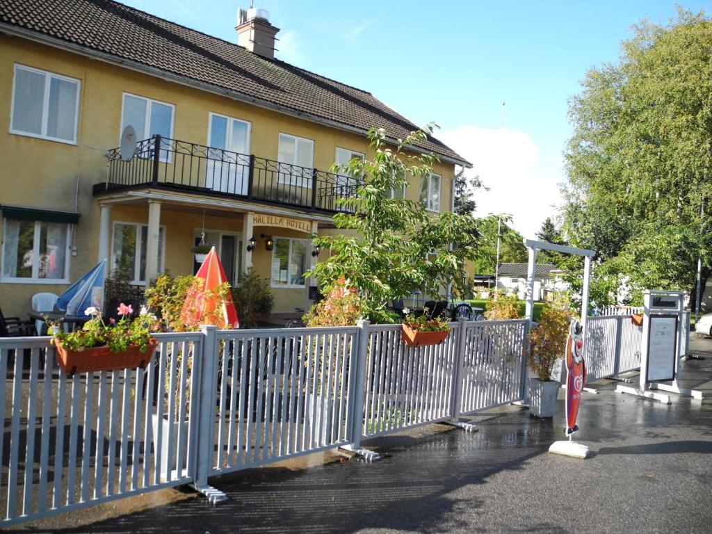 a fence in front of a house with potted plants at Målilla Hotell & Restaurang in Målilla