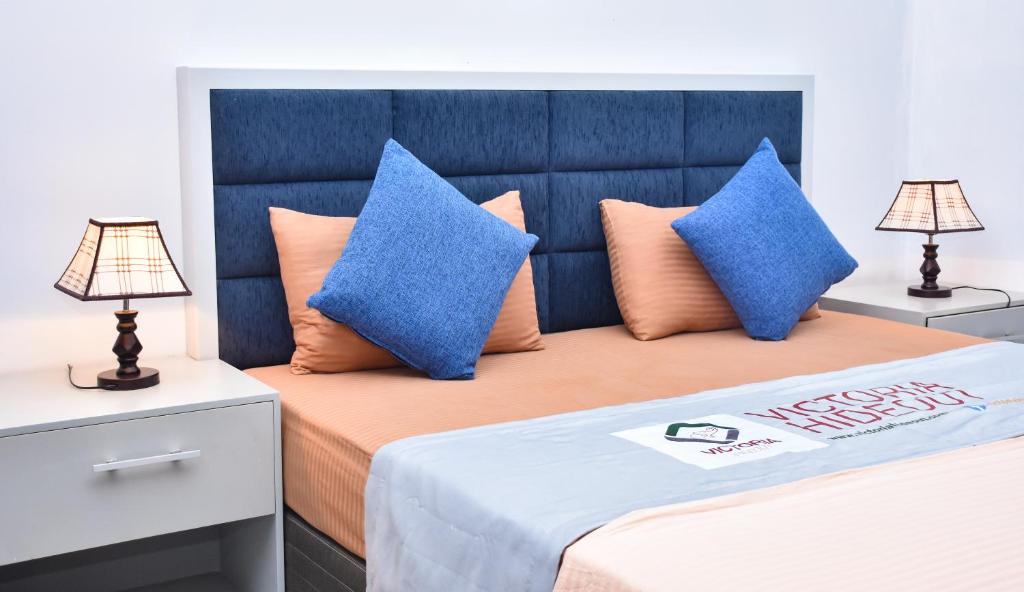 1 dormitorio con 2 almohadas azules en una cama en Victoria Hideout en Digana